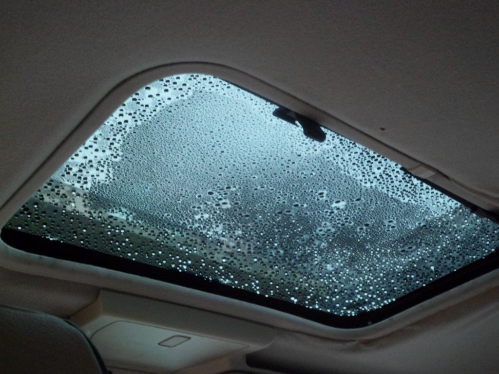 A car sunroof with excessive moisture on it