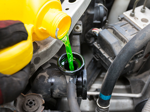 An engine is topped up with coolant.